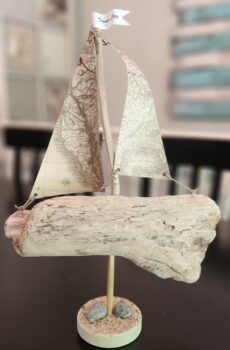 A Unique Sailboat Crafted from Driftwood, Petoskey Stones, Sand, Map Sails and Traverse City Flag