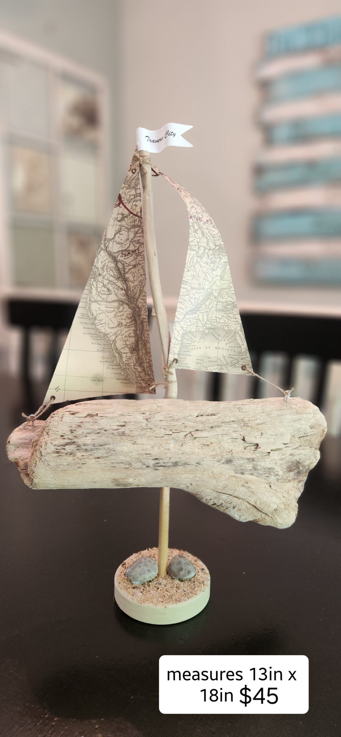 A Unique Sailboat Crafted from Driftwood, Petoskey Stones, Sand, Map Sails and Traverse City Flag