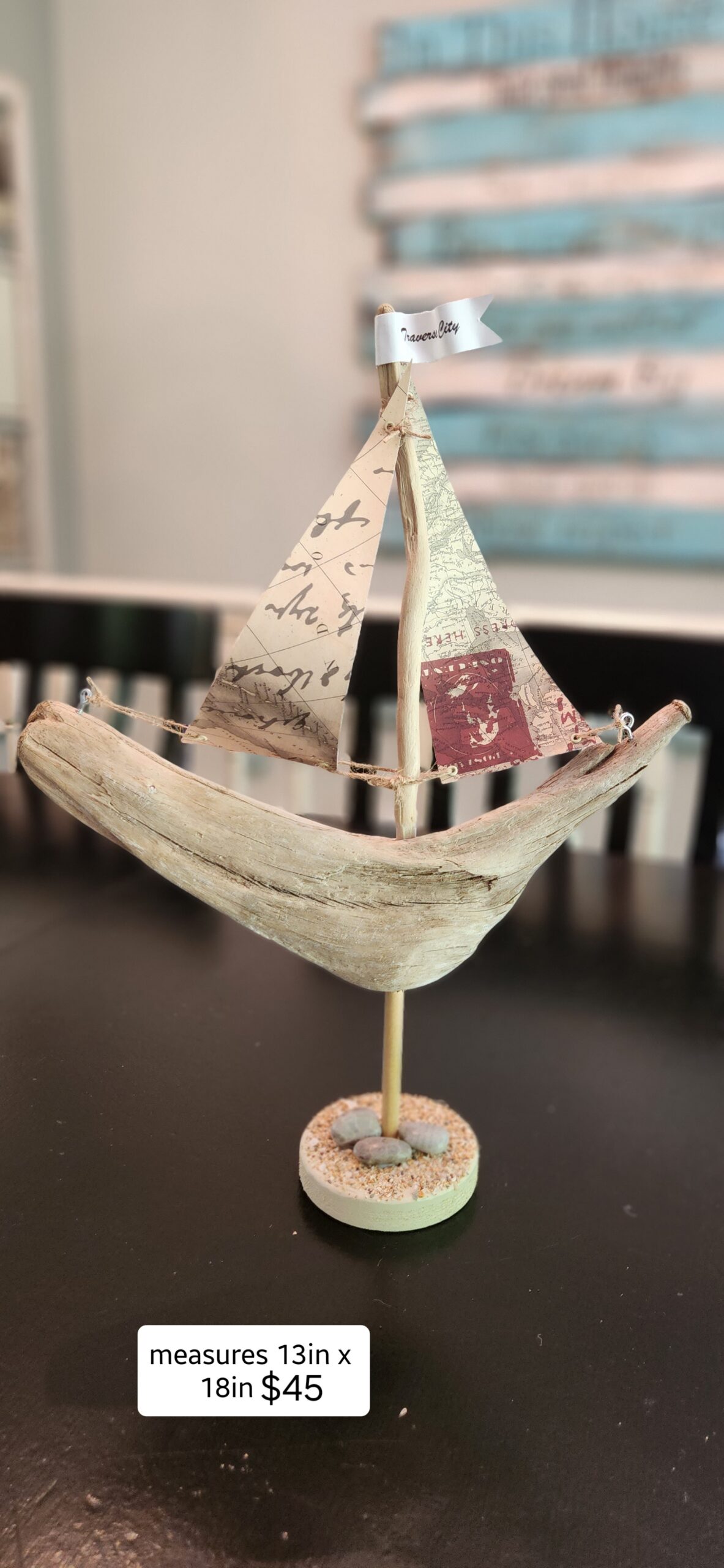 A Unique Sailboat Crafted from Driftwood, Petoskey Stones, Sand, and Map Sails & Traverse City Flag