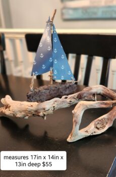 A Unique Sailboat Crafted from Driftwood setting on a unique piece of driftwood