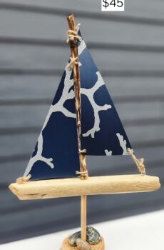 A Unique Sailboat Crafted from Driftwood, Charlevoix Stones, Sand, and Navy Sails